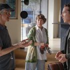 Vier Menschen in einem modernen Raum, zwei stehen im Vordergrund und sprechen miteinander.