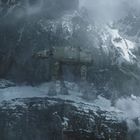 Drei große, vierbeinige Maschinen in einer verschneiten Gebirgslandschaft, umgeben von Nebel und felsigen Klippen.