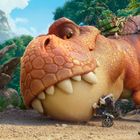 Ein kleiner Dalmatiner in Feuerwehrkleidung steht vor einem lächelnden, großen Dinosaurier im Dschungel.