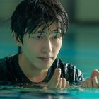 Ein junger Mann mit nassem Haar ist in einem Pool, schaut konzentriert und hat die Hände leicht erhoben.