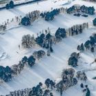 Text: "There is no bad time of year to play solo golf, no course condition that cannot be turned into a singular challenge."  
Verschneite Golfanlage mit Bäumen.