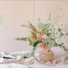 "Flower Care" Anweisungen zur Wasserpflege. Rechts neben einer Vase mit Blumenarrangement auf hellem Stoff.