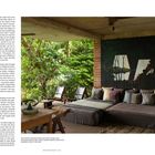 Texte über Architektur und Design. Moderne Einrichtung mit bequemen Sitzgelegenheiten vor üppigem, grünem Dschungelhintergrund.