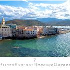 St. Florent. Kalender mit Nummern 1 bis 31. Küstenort am Wasser mit alten, farbigen Häusern, Berge im Hintergrund.
