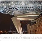 Kalenderblatt mit Datum 7 und 25. Antwerpener Bürogebäude bei Nacht; modernes und historisches Gebäude kombiniert.