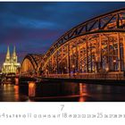 Texte: "Deutzer Brücke", "7", "CASARES EDITION". 

Große beleuchtete Eisenbahnbrücke, außen eine beleuchtete Kathedrale, im Hintergrund Himmel bei Sonnenuntergang.