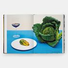 Links: "Pigeon and black pudding-stuffed cabbage". Ein großer Wirsingkopf und ein Glas Rotwein auf blauem Tischtuch.