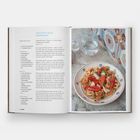 Text: "CUSCUSU ALLA TRAPANESE. Preparation time: 2½ hours + 2½ hours resting. Cooking time: 45 minutes. Serves 6–8."

Links Rezepttext, rechts Teller mit Couscous und Meeresfrüchten. Im Hintergrund Flaschen und Fliesenmuster.