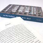 Ein aufgeschlagenes Buch zeigt das Kapitel "Endspiele". Im Hintergrund ein Buchcover mit "KÜHLE NEUE WELT".
