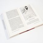 Offenes Buch mit Text auf Deutsch. Rechts ein Foto eines Mannes mit Bart, daneben handgeschriebener Text.