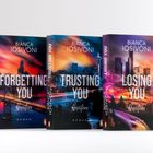 "FORGETTING YOU", "TRUSTING YOU", "LOSING YOU", alle von Bianca Iosivoni. Drei Bücher mit Stadtansichten bei Sonnenuntergang.