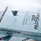 Buchtitel: "Der Prätorianer". Text: "Er mordet meisterhaft. Er kennt keine Gnade. Er ist...". Abbildung einer realistisch gezeichneten Fliege.