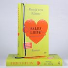 Ein gelbes Buch mit dem Titel "ALLES LIEBE" von Ronja von Rönne, zeigt ein gebrochenes rotes Herz.