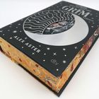 Auf dem Buch stehen die Wörter "GRIM" und "ALEX ASTER". Es hat ein schwarz-silbernes Cover mit kosmischen Mustern.