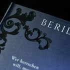 Text: "BERIL KEN II". Darunter ein Zitat: "Wer herrschen will, muss..." Verzierungen in floraler Form am Rand.