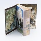 Eine geöffnete Buchhülle zeigt eine Karte mit "Shenzhou - Göttliches Land" und Reitern vor Wolken.