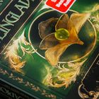 Text: „STEINGLAD“ und „ERDE VERGISST NIE“. Eine goldene Blume mit grünem Kern auf grünem Hintergrund mit Verzierungen.