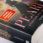 SPIEGEL Bestseller-Autorin, PEARL: KÖNIGIN DER MEERE. Roman von Goldmann. Tropische Szene mit einer Frauensilhouette.