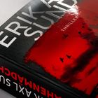 Text: "ERIK AX. SUND THRILLER". Ein Buchcover mit rotem Himmel und schwarzen fliegenden Vögeln.