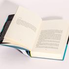 Aufgeschlagenes Buch auf Seite 32-33, schwarzer Text auf cremefarbenem Papier, Hintergrund weiß, Einband türkis und schwarz.