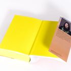 Ein gelbes Buch mit einem Lesezeichen. Das Lesezeichen zeigt ein Porträtfoto und den Text "Aisling Rawle".