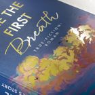 Texte: "LIKE THE FIRST Breath", "TRUE-FICTION-ROMAN", "BASED ON". Stilvolle Buchcovergestaltung mit illustriertem Himmel.