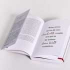 Ein aufgeschlagenes Buch zeigt den Text: „Wenn etwas tief in dir eine Geschichte erzählt, hör gut zu. Sie könnte deine Welt verändern.“