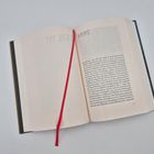 Text: „ANNE“, darunter Fließtext; Buch liegt offen, rote Stoffmarkierung.
