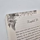 Text "Kapitel 34". Seite mit floralen Illustrationen am Rand, fließender Text darunter.