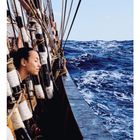 Kalenderansicht mit: "07" und Zahlen von 01 bis 31. Ein Mensch schaut aufs Meer von einem Segelschiff aus.