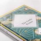 Ein Buch mit dem Titel "The Little Prince" von Antoine de Saint-Exupéry. Verspielte Illustrationen schmücken das Cover.