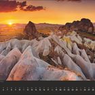 Kalenderseite Juli, Landschaft in Kappadokien, Sonnenuntergang über Felsenformationen und einem weiten Tal im Hintergrund.