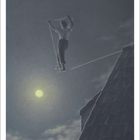 Zahl 7 unten. Ein Seiltänzer balanciert nachts zwischen einem Dach und einem fernen Punkt, beleuchtet vom Mond.