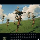 Kalendarium mit Juli-Daten, unten "07". Illustration: Roboter auf fliegenden Fahrzeugen über grünem Hügel vor Wolken.