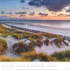 Text: "JULI". Dünenlandschaft mit Strand und Meer bei Sonnenuntergang, Himmel mit Wolken, grasbedeckte Hügel.