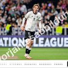 "Voriges Bild" in großen Buchstaben, Spieler in weiß-schwarzem Trikot, Fokus im Stadion, Kalender unten, Nummer 07.
