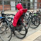 Am Gebäude stehen Schilder mit "Ausländerbehörde" und "Türöffner". Davor sind Fahrräder, eines mit roter Abdeckung.