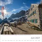 Juni 2027. Kalender. Berghütte mit Holzbänken, Berglandschaft im Hintergrund, Flagge im Wind, sonniger Himmel.