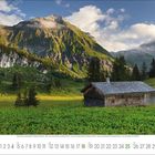 7 Juni, Samstag; Berglandschaft mit Hütte im Vordergrund, üppige grüne Wiesen, imposante Berge im Hintergrund, bewölkter Himmel.
