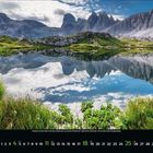 August. Kalender mit Sonnenuntergang über dem Meer, bunte Wolken am Himmel, Wellen berühren den Sandstrand.