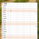 Kalenderblatt für Juli 2027. Wochentage und Daten sind aufgelistet. Foto: Hütte mit rotem Dach neben einem Weg in grüner Landschaft.