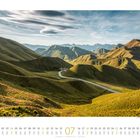 Kalenderblatt für Juli. Landschaft mit grünen Hügeln und einer kurvigen Straße. Wolken schweben am blauen Himmel.