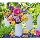 07; Kalender Juni und Juli-Übergang; Blumenstrauß in weißer Kanne vor Holzzaun. Farbenfrohe Blumen im Garten.