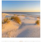 Kalender zeigt Juli, Wochentage in Spalten. Dünenlandschaft mit Gräsern bei Sonnenuntergang am Strand.
