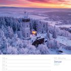 03. Woche, Januar 2027. Winterlandschaft mit einer Burg und schneebedeckten Bäumen bei Sonnenuntergang.