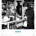 Januar. Eine Verkäuferin berät eine Kundin in einem kleinen Laden. Regale sind mit verschiedenen Produkten gefüllt.