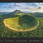 Kalenderseite mit den Zahlen 1 bis 31. Vulkanlandschaft mit grün bewachsenen Hügeln und klarem Himmel.