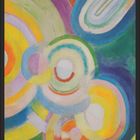 Juli-Kalenderblatt mit abstraktem, buntem Gemälde aus Kreisen und Bögen in leuchtenden Farben.