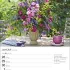 Juni/Juli-Kalender, 26. Woche. Zitat: "Am leuchtenden Sommermorgen...". Blumenstrauß in lila-rosa Farben auf einem Tisch.