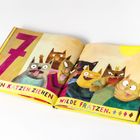„Sieben Katzen ziehen wilde Fratzen.“ Illustration von sieben bunten Katzen mit lustigen Gesichtsausdrücken.